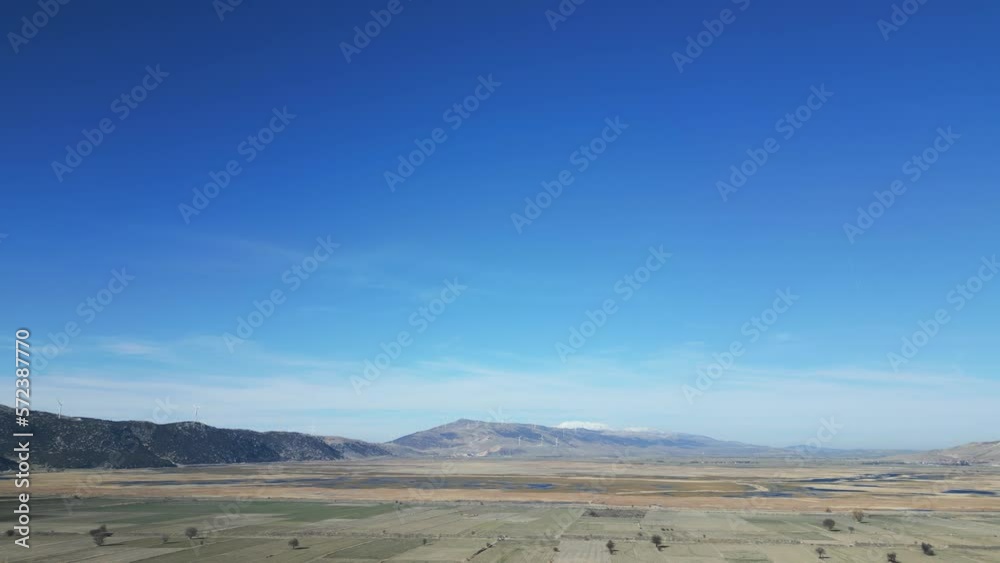 Aerial shot, the camera is flying through mountainous terrain, with windmills located on the hills. High quality 4k footage Aerial shot, the camera is flying through mountainous terrain, with windmills located on the hills. High quality 4k footage