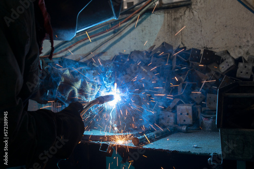 Industrial steel welder in a factory. Welder at work.