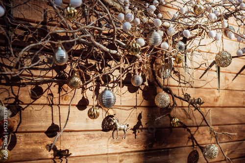New Year's decoration on tree branches near a wooden wall