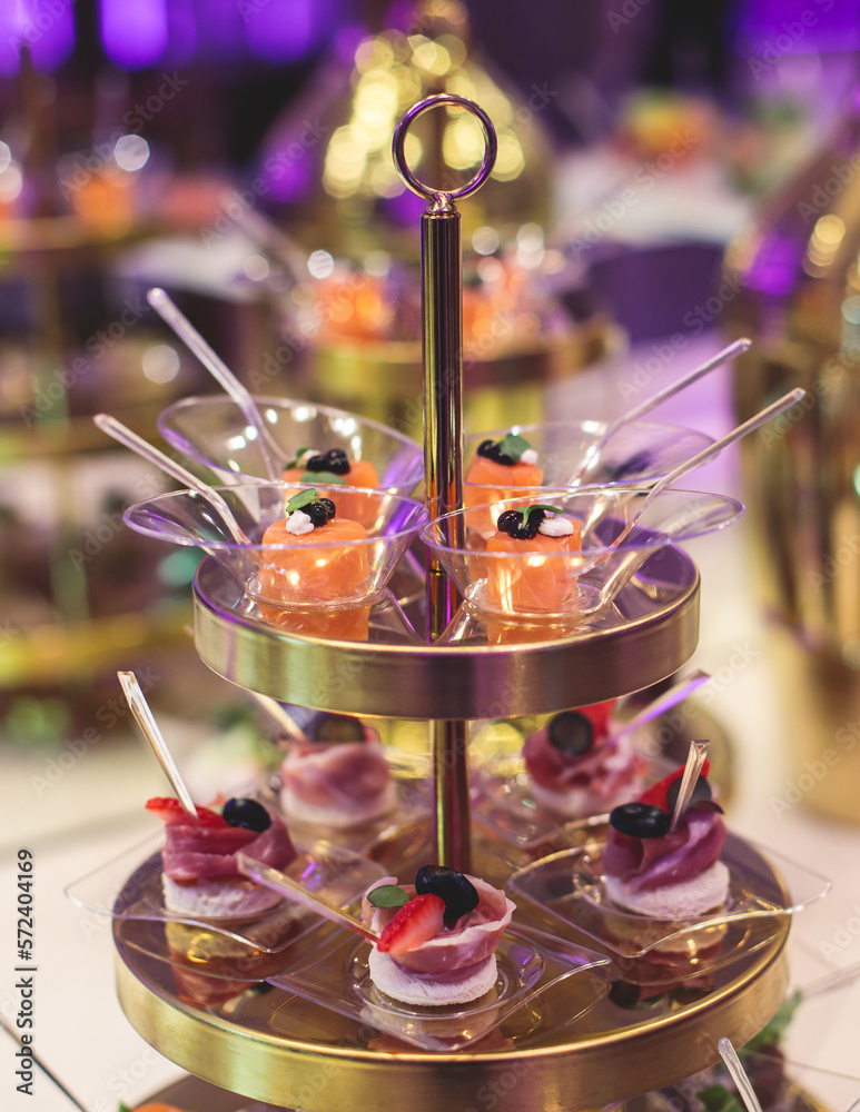 Beautifully decorated banquet catering table with variety of different food snacks, sandwiches, croissants and appetizers on a party event or celebration, delicatessen setting, coffee break