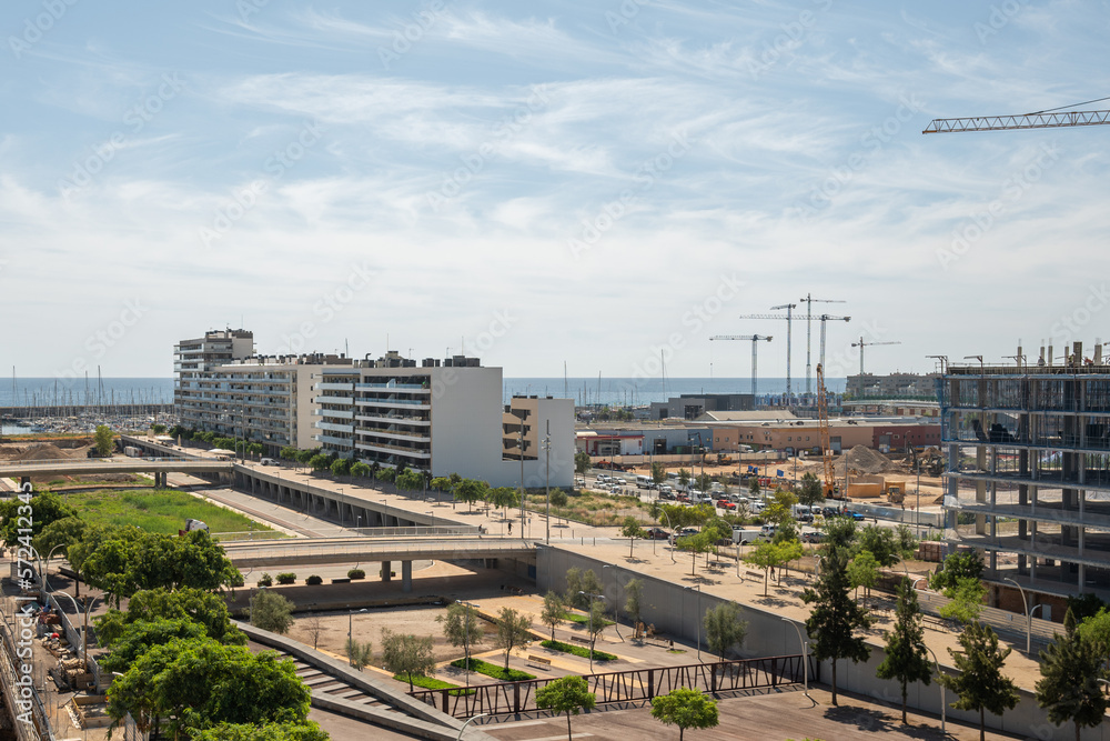 Gorg area in Barcelona, Spain, with many new and under construction residential buildings. Park areas with architectural bridges. In the distance, the ocean and blue sky merge into the horizon lines. Gorg area in Barcelona, Spain, with many new and under construction residential buildings. Park areas with architectural bridges. In the distance, the ocean and blue sky merge into the horizon lines.
