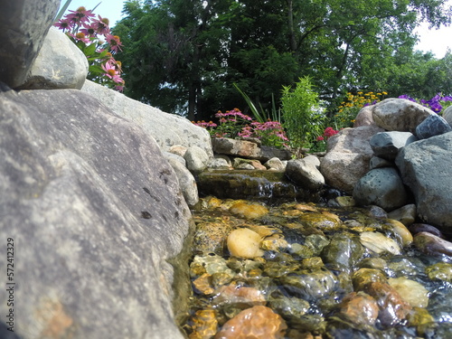 Closeup of small waterfall and stream in a backyard water feature.