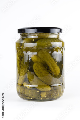 Pickled cucumbers in a glass jar. Preserved pickled gherkins on white background. 
