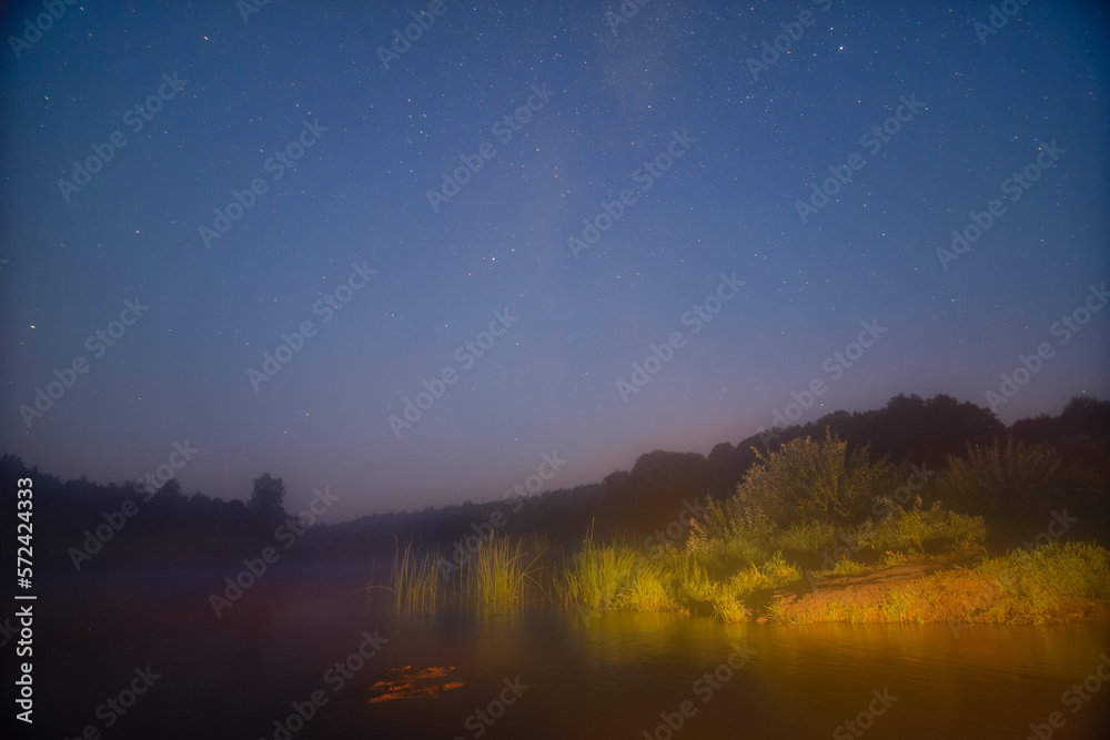 Naklejka premium Milky way over river at twilight