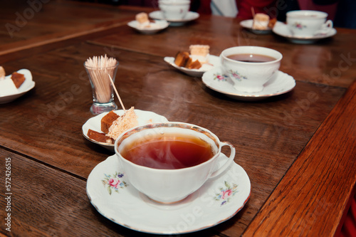 porcelain cups with tea and natural apple pastille on a wooden table in a cafe
