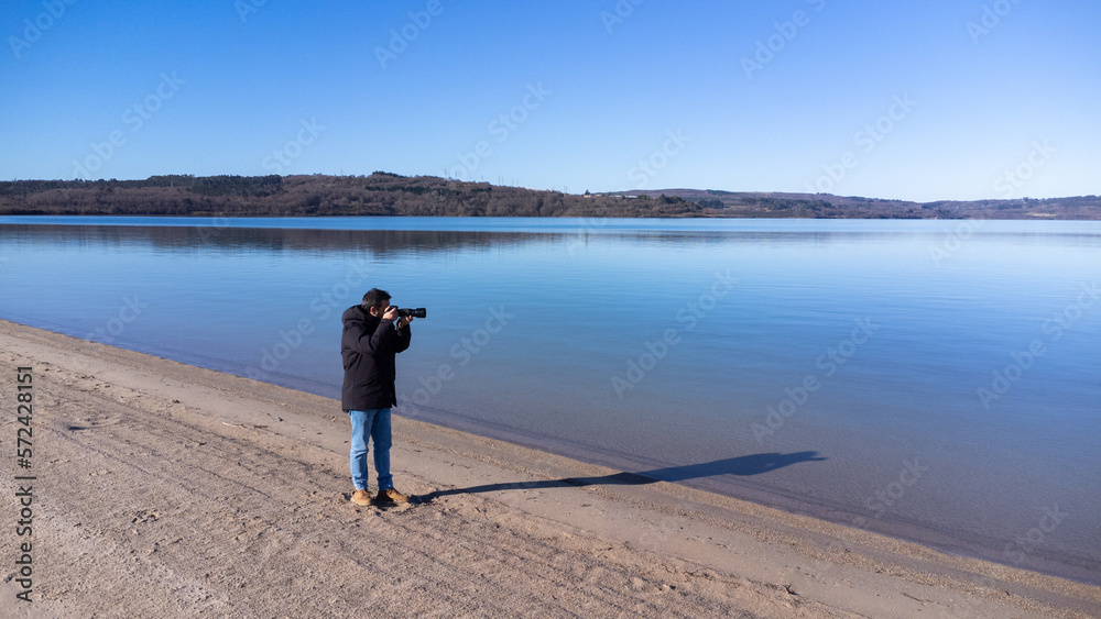 Photographer taking photos of a beach landscape with a summer sunset