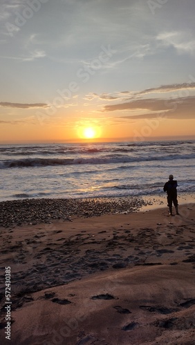 fisherman on the beach at sunset