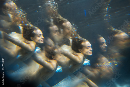 Young beautifull caucasian woman in dress under water
