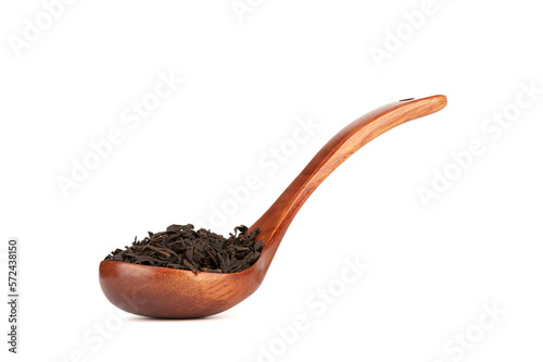 Black loose leaf tea on an elegant wooden spoon over a white background.