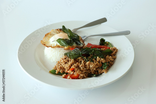Pad Kra Pow with chicken in bowl with rice and fried thai basil