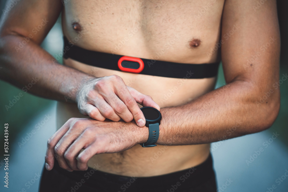 Unrecognizable man with a band around his chest measuring his pulse during activity