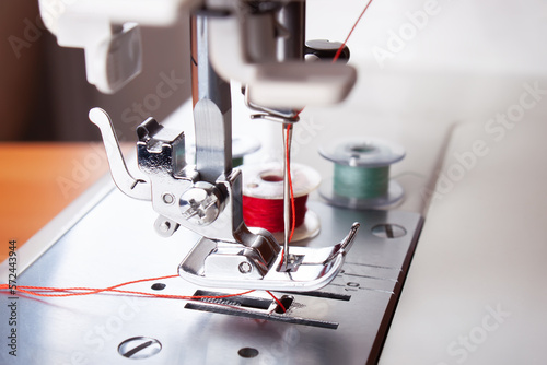 Obraz na płótnie Modern sewing machine presser foot, needle with thread and spool, closeup