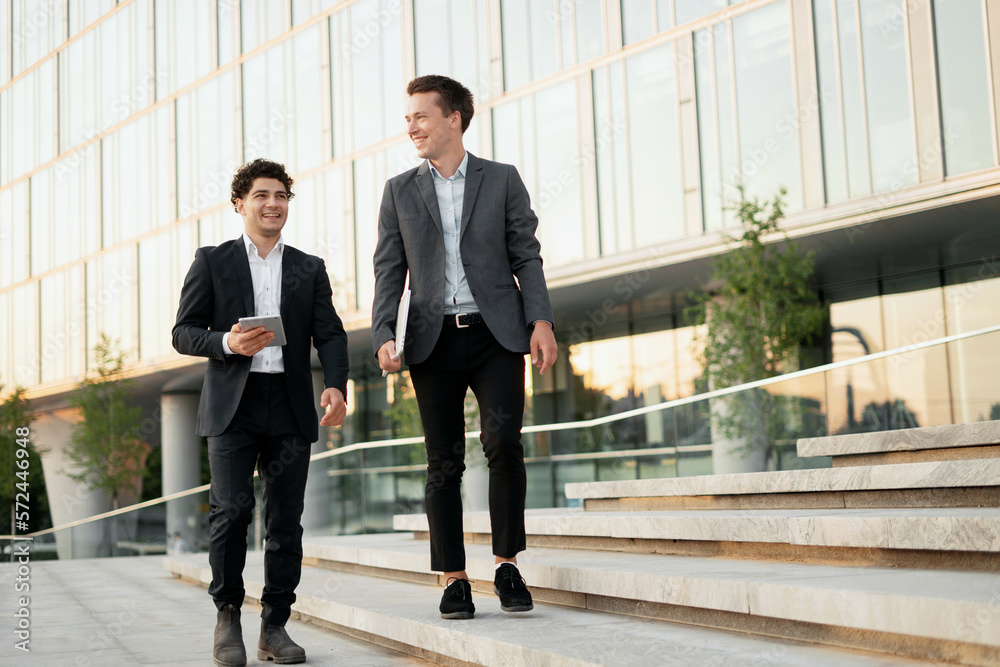 Lawyers colleagues in business suits are young successful entrepreneurs. Two men team communication break drinking coffee going to the office in coworking. Lawyers colleagues in business suits are young successful entrepreneurs. Two men team communication break drinking coffee going to the office in coworking.