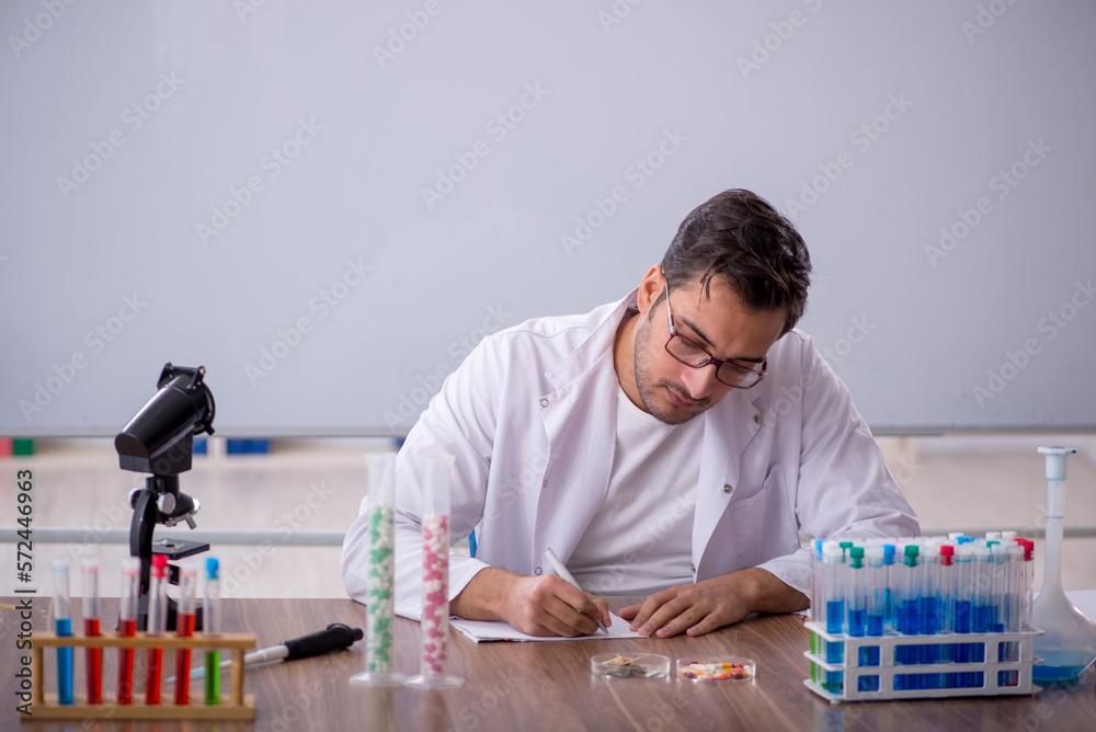 Young male chemist in front of white board Young male chemist in front of white board