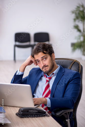 Young male employee and too much work in the office