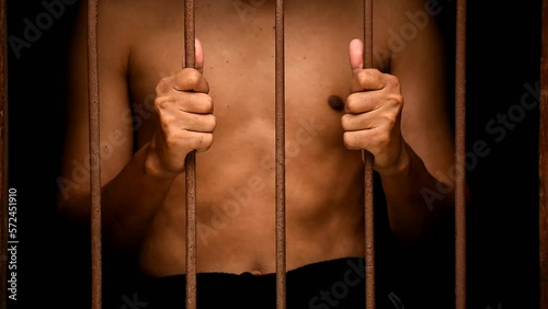 hand man hold steel in jail on black background in black and white tone.concept for prisoner,sadness,detain,erroneousness