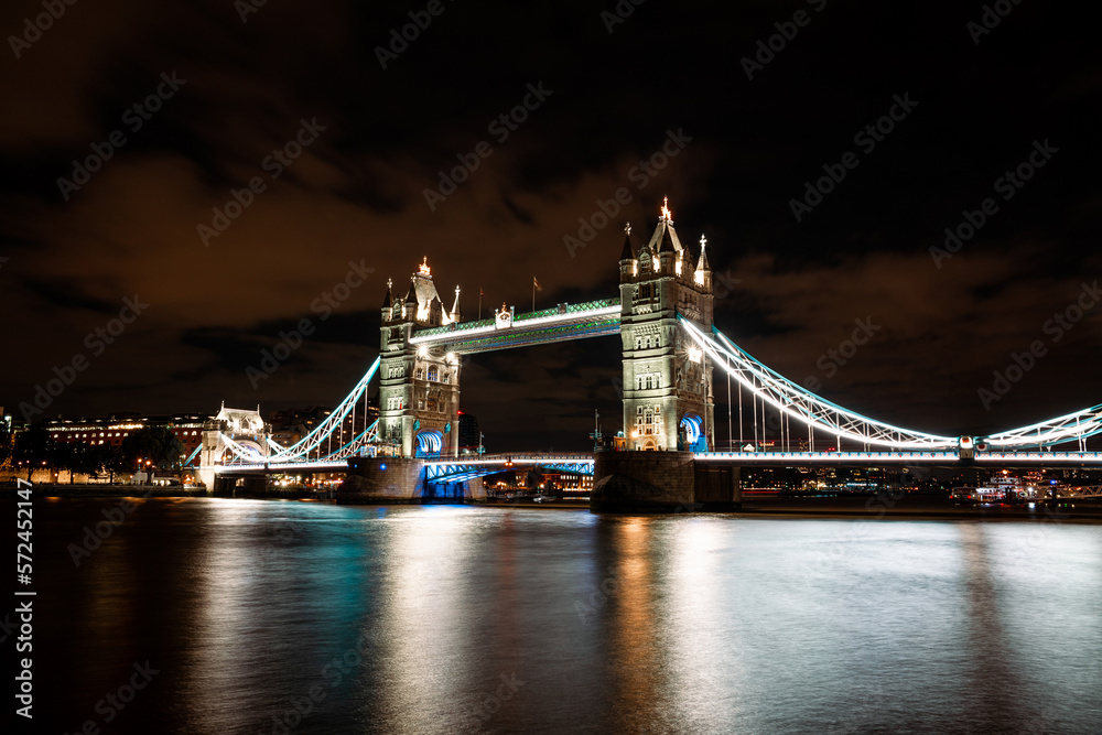 Fototapeta premium Tower Bridge Illuminated at Night, London's Iconic Landmark Lighting Up the River Thames