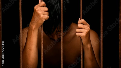 hand man hold steel in jail on black background in black and white tone.concept for prisoner,sadness,detain,erroneousness