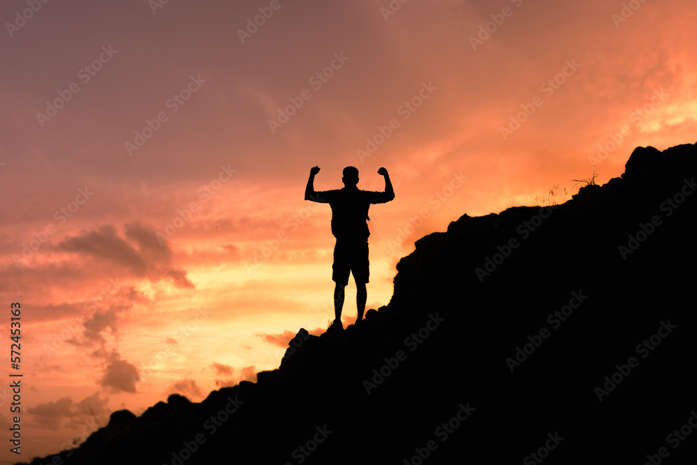 Strong man reaching the top of mountain.  Setting goals concept. 