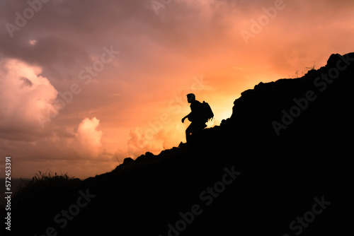 Man sitting on a mountain cliff edge looking out into the distant view