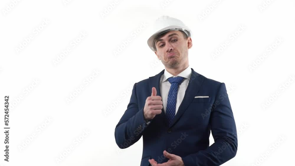 A man businessman in a suit and in a protective helmet on a white background thinks about solving a problem and looks at his watch. A man businessman in a suit and in a protective helmet on a white background thinks about solving a problem and looks at his watch.