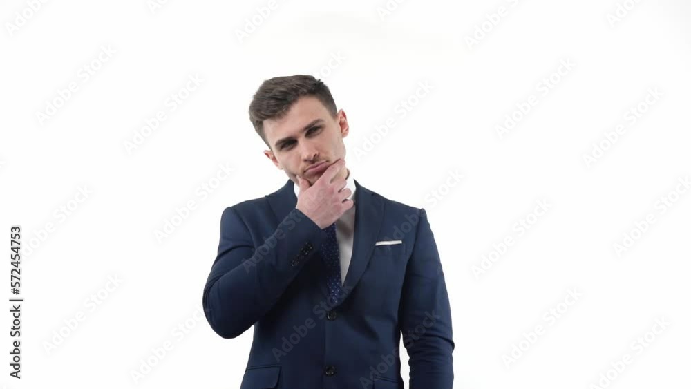 Handsome male businessman in a suit conceived about solving a problem. Holding on to the beard in studio on a white background. Handsome male businessman in a suit conceived about solving a problem. Holding on to the beard in studio on a white background.
