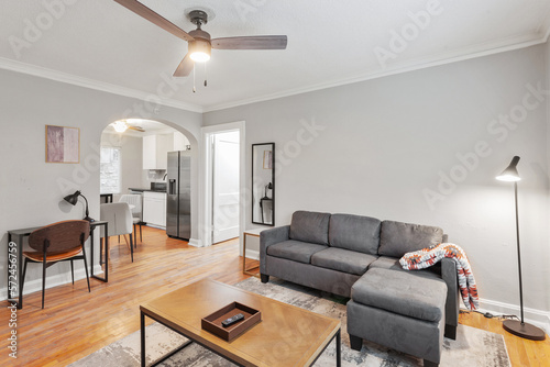 White apartment with wide open spaces, hardwood flooring and modern furniture. Used as a short term rental. 