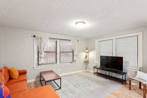 White apartment with wide open spaces, hardwood flooring and modern furniture. Used as a short term rental. 