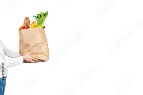 Food delivery, online grocery shopping or donation concept. Store shopping woman or courier holds a paper bag filled with groceries isolated on white background. Banner with copy space