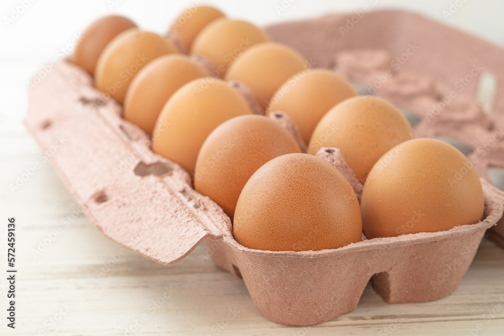 Open egg box with twelve brown eggs isolated on white background with clipping path. Fresh organic chicken eggs in carton pack or egg container with copy space. Recycled cardboard box with a dozen egg Open egg box with twelve brown eggs isolated on white background with clipping path. Fresh organic chicken eggs in carton pack or egg container with copy space. Recycled cardboard box with a dozen egg