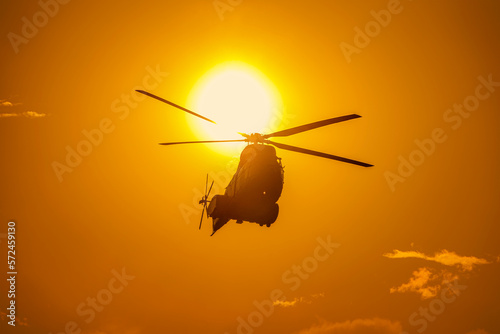 Fototapeta Naklejka Na Ścianę i Meble -  Helicopter in front of the sun at sunset