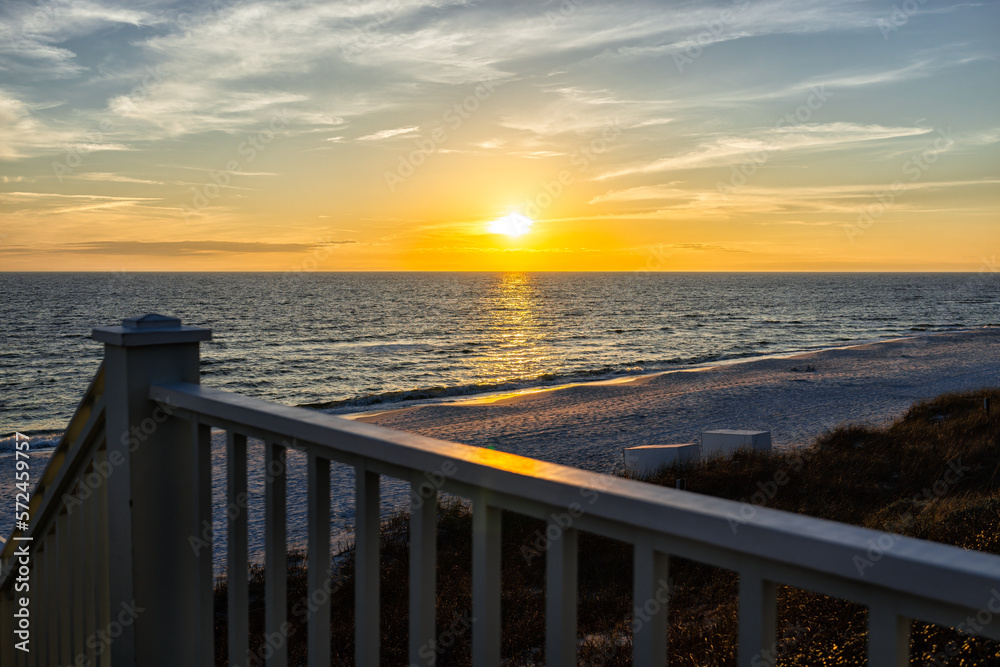 Obraz premium High angle view of wooden boardwalk railing steps leading to beach at Gulf of Mexico in Seaside, Florida panhandle yellow sunset and nobody