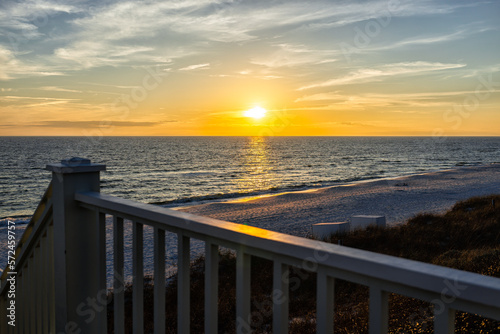 High angle view of wooden boardwalk railing steps leading to beach at Gulf of Mexico in Seaside, Florida panhandle yellow sunset and nobody