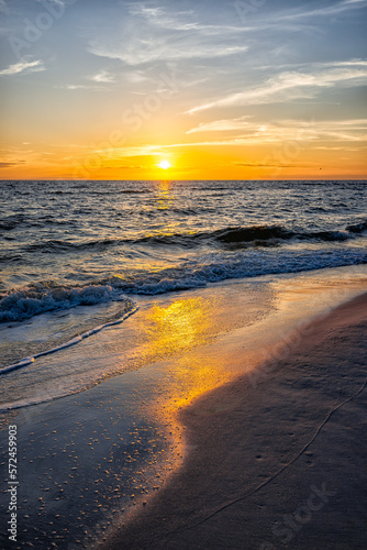Colorful vertical sunset seascape and sun horizon in Gulf of Mexico sea ocean coast with water waves in Seaside Santa Rosa Beach, Florida panhandle and reflection of path photo