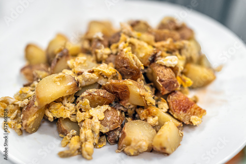 Canvas Print Macro closeup of breakfast or brunch cubed potatoes fried hash on white plate wi