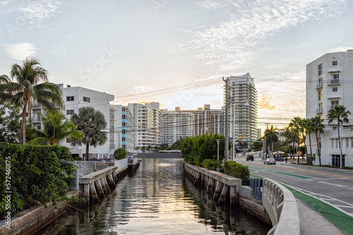 South Beach, Miami in evening sunset with condo apartment buildings in Florida with tropical palm trees and intracoastal canal water by street road photo