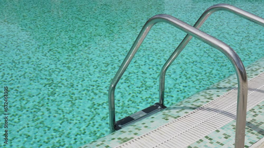 Staircase made of steel railing to enter the blue water of the pool in the hotel villa. Slow motion. Staircase made of steel railing to enter the blue water of the pool in the hotel villa. Slow motion.