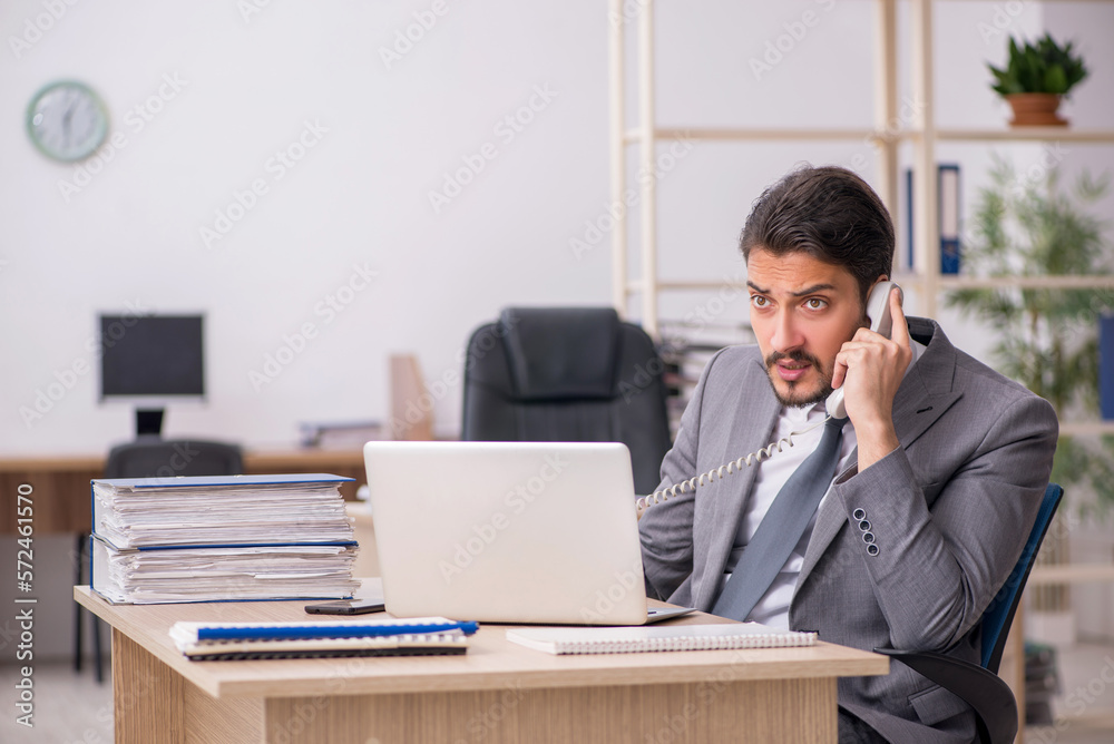 Young male employee working in the office Young male employee working in the office