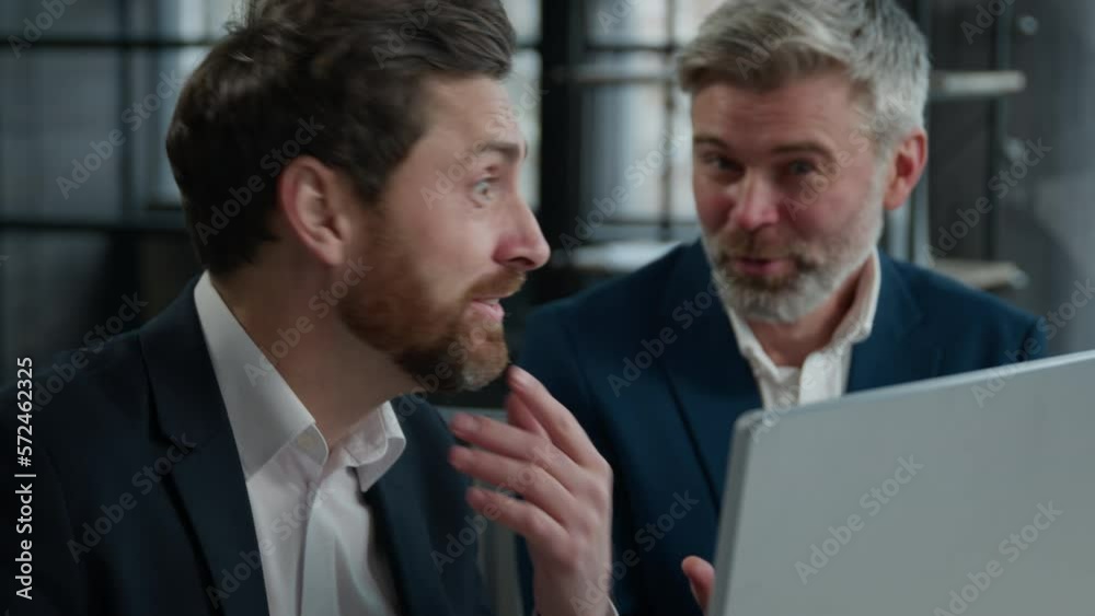 Close-up two surprised caucasian men different ages businessmen colleagues look in surprise at computer screen amazed corporate employees business partners receive good news win satisfied achievement Close-up two surprised caucasian men different ages businessmen colleagues look in surprise at computer screen amazed corporate employees business partners receive good news win satisfied achievement