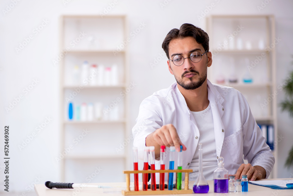 Young male chemist working at the lab Young male chemist working at the lab
