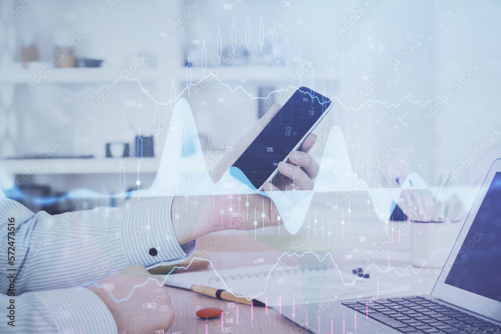 Double exposure of man's hands holding and using a digital device and forex graph drawing. Financial market concept. Double exposure of man's hands holding and using a digital device and forex graph drawing. Financial market concept.