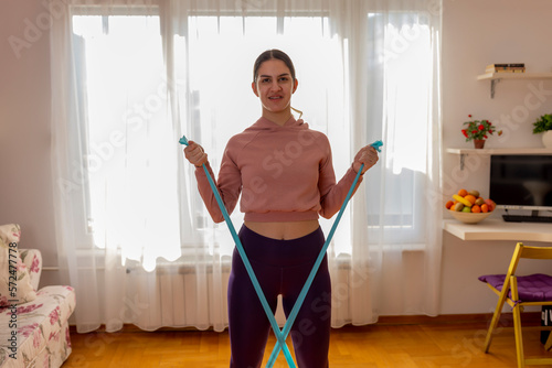 Online workout. Teen girl doing Sport exercise at home, watching tutorials on a laptop. How to keep fit indoors