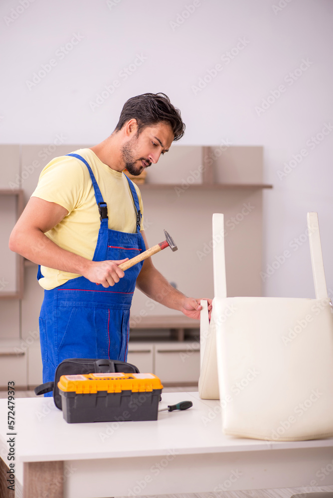 Young male carpenter repairing chair at home Young male carpenter repairing chair at home