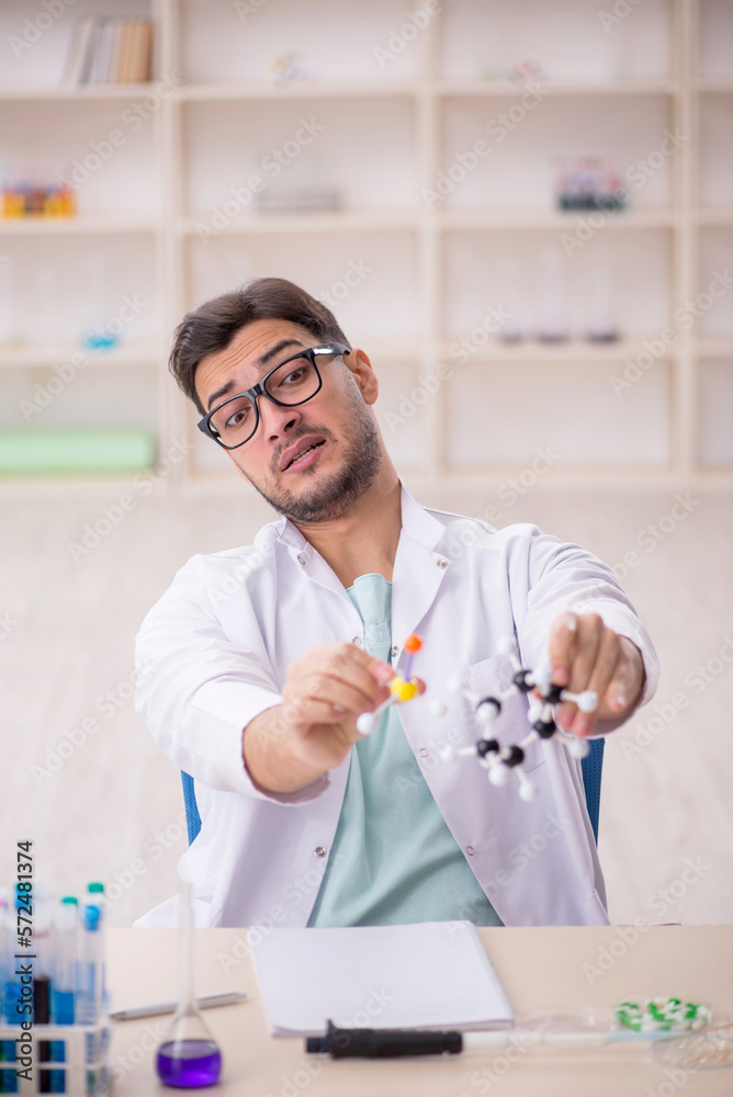 Young male chemist sitting at the lab Young male chemist sitting at the lab