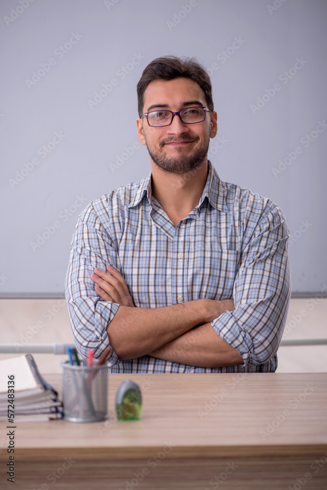 Young male teacher in front of white board Young male teacher in front of white board