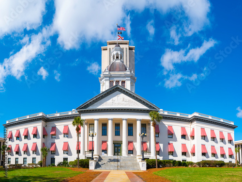 Historic Florida State Capitol Building with brightly colored striped awnings, classical style dome, and American and Florida State Flags in Tallahassee photo