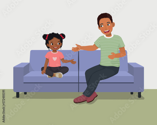 Young African father talking to his daughter sitting on sofa giving advises encouragement and support 
