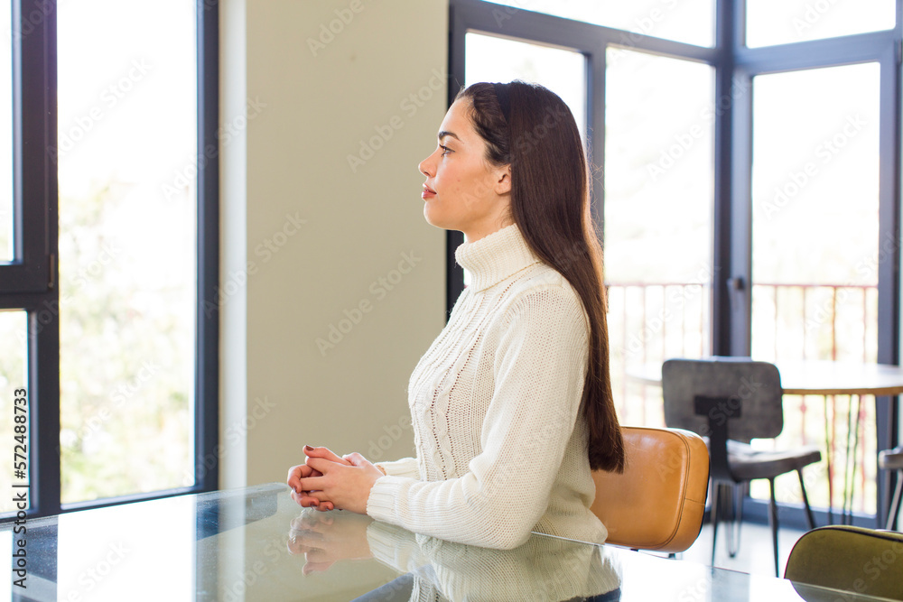 pretty caucasian woman on profile view looking to copy space ahead, thinking, imagining or daydreaming pretty caucasian woman on profile view looking to copy space ahead, thinking, imagining or daydreaming