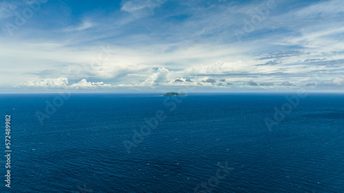 Blue sea and tropical island Apo against blue sky and clouds. Philippines.