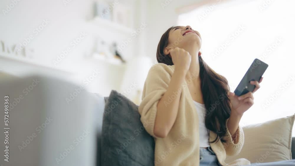 Happy young asian woman relax on comfortable couch at home texting messaging on smartphone, smiling girl use cellphone, chatting online message, shopping online from home